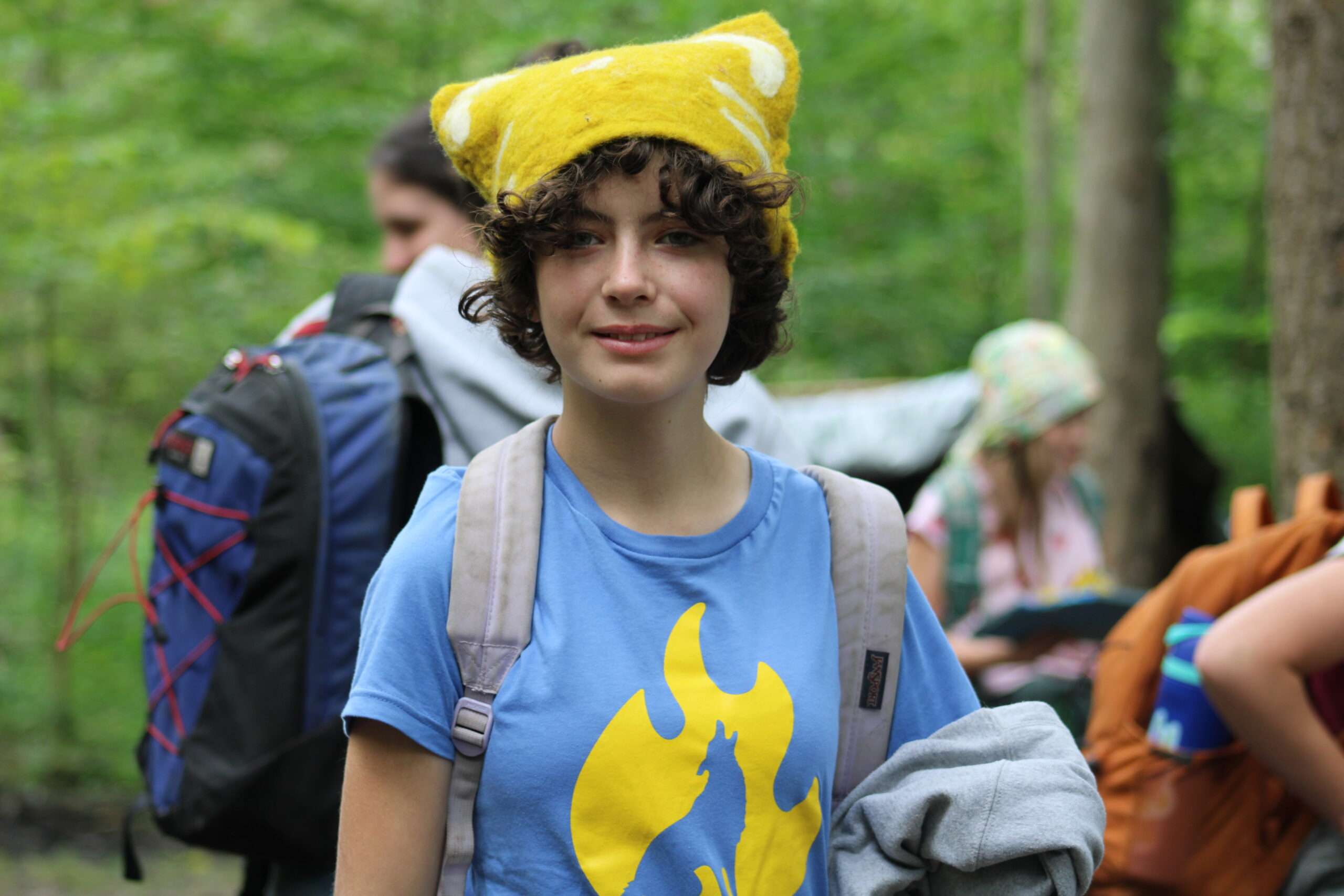 Child with a yellow hat in the woods. 