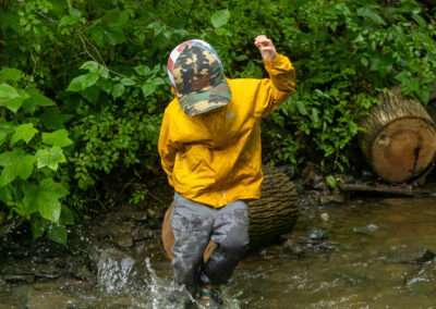 A younger camper splashing around in the creek.