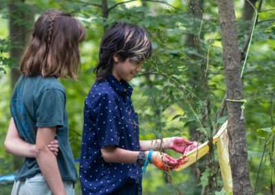 Two campers admiring a bandana dyed with wild berries.