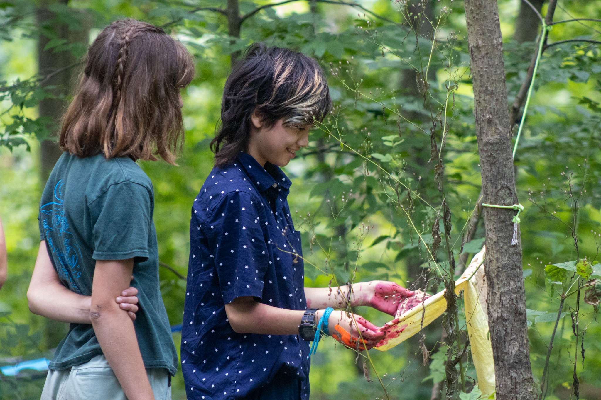 Two campers admiring a bandana dyed with wild berries.