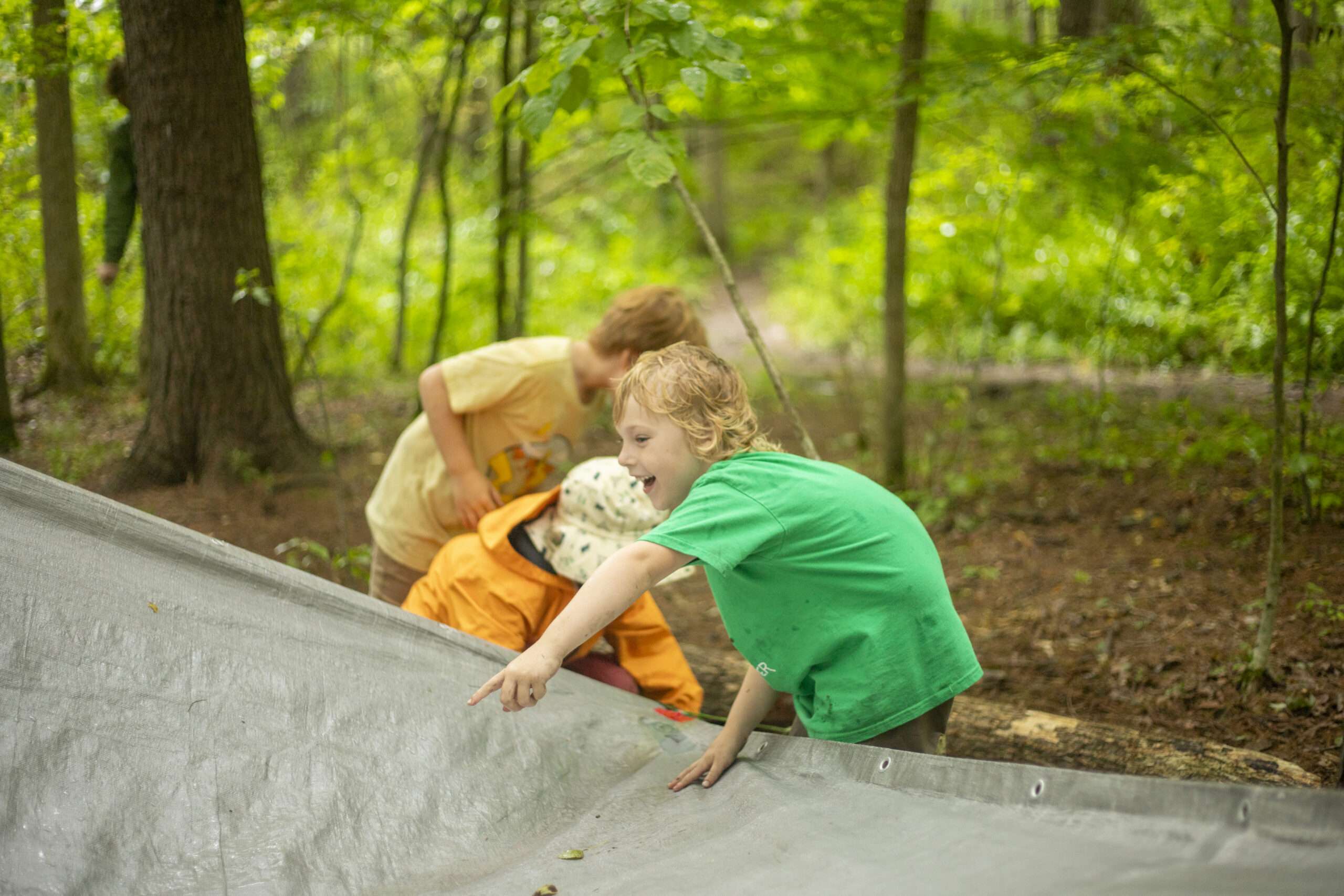 camper smiling and pointing at something on a tarp