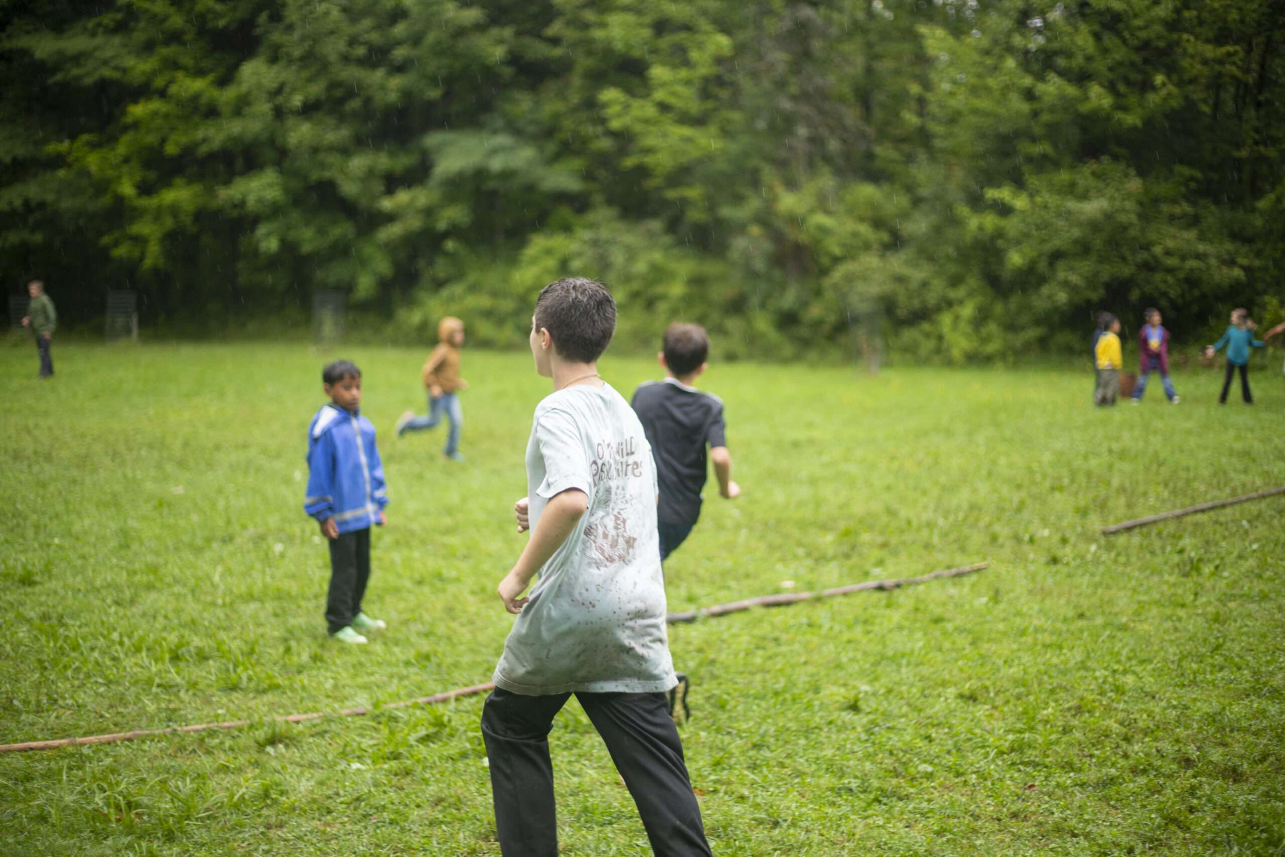 wide shot of a camper running in a field playing a game