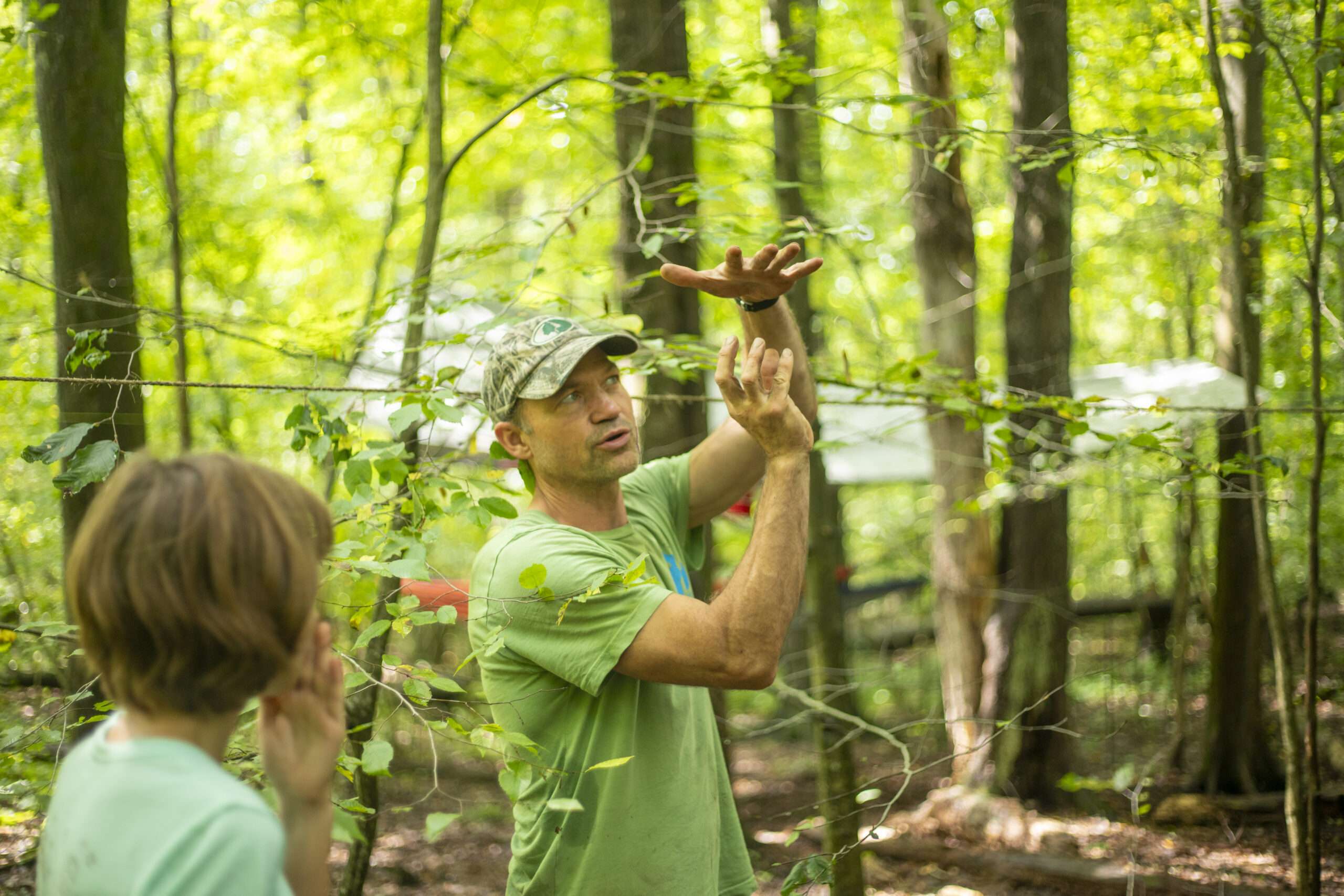 an adult instructor showing a kid something with their hands